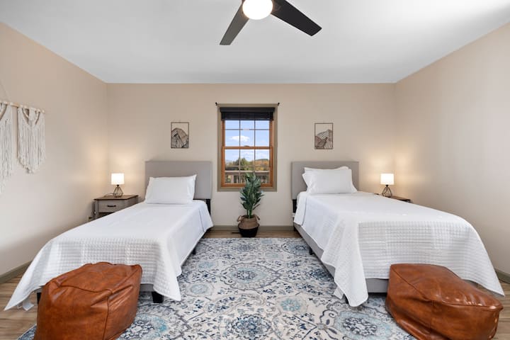 Comfortable twin bedroom thoughtfully designed for siblings, cousins, children, or additional guests with cozy accommodations and easy access to shared gathering spaces throughout the home.