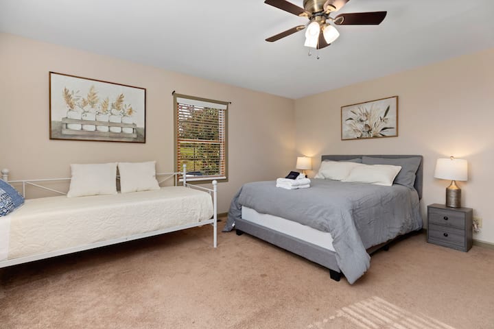 Spacious guest bedroom with inviting natural light, comfortable bedding, and peaceful surroundings designed to help families and guests relax during graduation weekends, university visits, and longer stays.