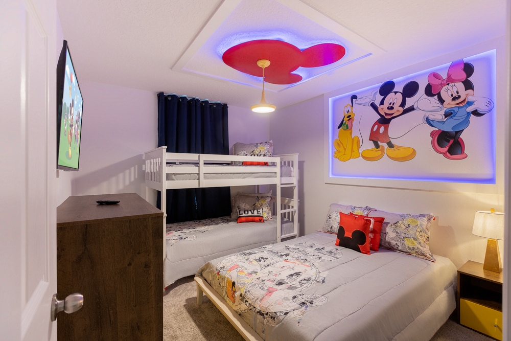 Plongez dans les rêves de Disney dans cette chambre superposée ludique : un ensemble superposé blanc entièrement doublé avec une literie Mickey impeccable fait face à une télévision murale. Des accents LED lumineux mettent en valeur une fresque Mickey et Minnie emblématique, tandis qu'une commode élégante et un tapis confortable sont complets.       