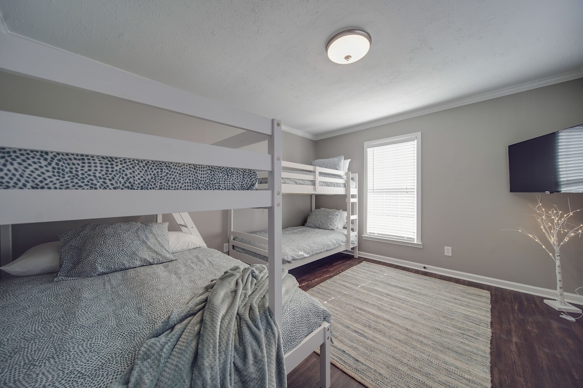 Vitanda vya ghorofa katika chumba cha kulala cha tatu (ukubwa mmoja kamili na vitanda vitatu vya ukubwa wa mapacha) na Televisheni mahiri.