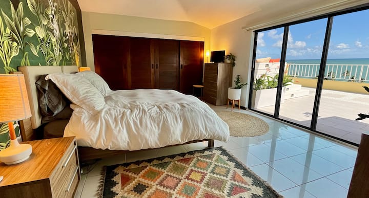 Chumba bora cha kulala chenye mandhari ya Bahari ya Karibea wakati umelala kitandani. Stendi mbili za usiku, kifua kikubwa cha droo, kabati kubwa, stendi mbili za usiku na bafu la En Suite. Na ninajivunia hasa ukuta wa kitropiki wa vigae vya kauri nyuma ya ubao wa kichwa.