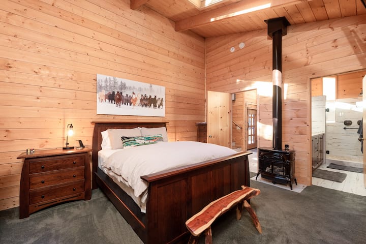 El dormitorio principal cuenta con techos abovedados, tragaluces espectaculares y una estufa de hierro vintage.
