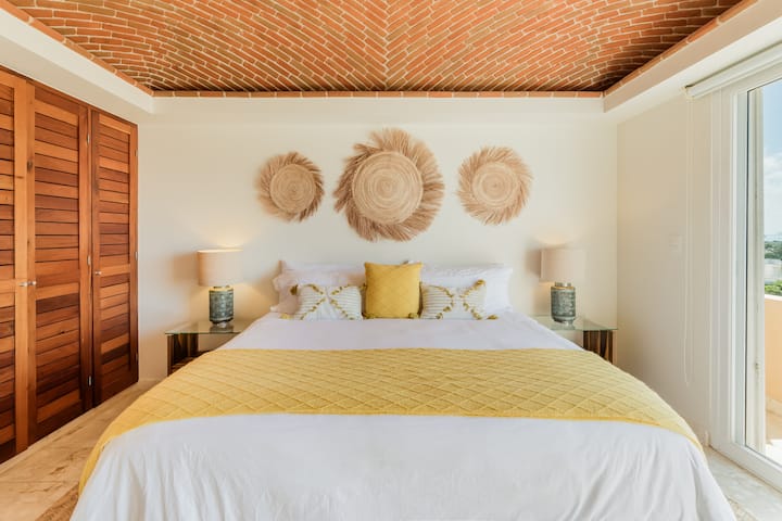 Chumba cha kulala cha kifahari chenye kitanda aina ya king, kina dari ya matofali iliyojikunja na mapambo ya kisanii.