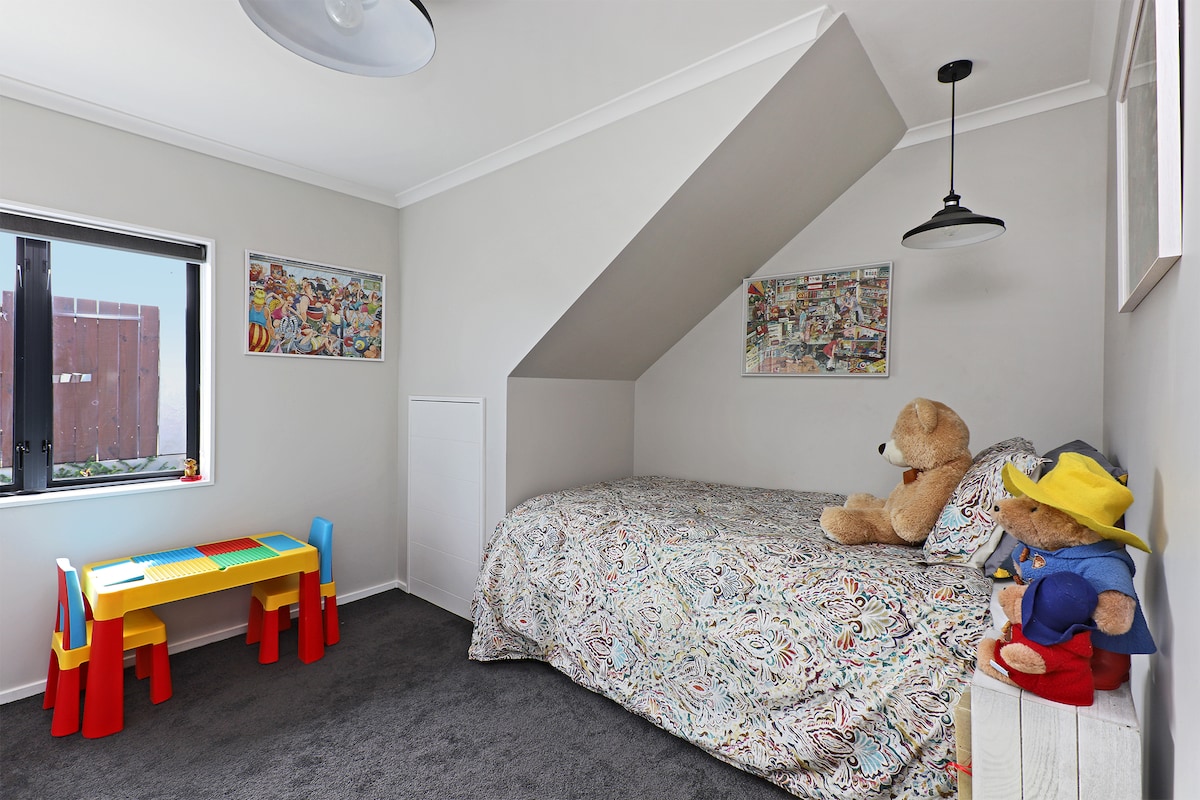 Dormitorio 4 con una cama principal tamaño king y otra cama individual debajo de esta cama . Tiene un armario y sorteos y la opción de una cuna portátil, con muchos juguetes y libros para niños. 