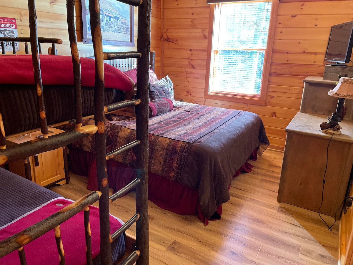 Спалня в сутерен със западна тематика, със суперголямо двойно легло и две единични легла.