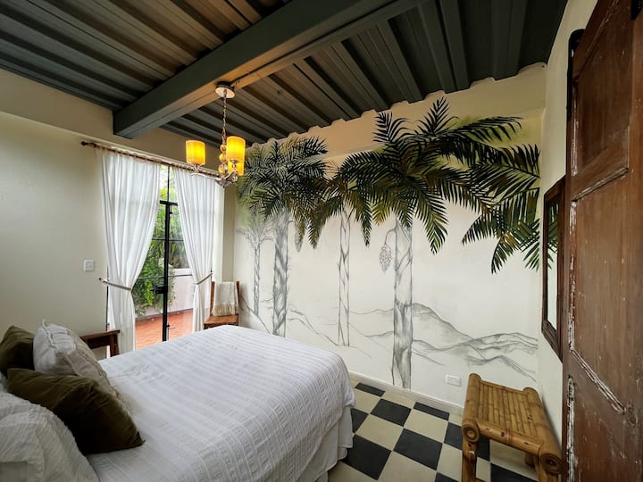 Habitación #1 พร้อมที่นอนและผ้าปูที่นอนขนาดควีนไซส์คุณภาพระดับโรงแรม ห้องพักแต่ละห้องในชั้นล่างมีพัดลมตั้งพื้นขนาดใหญ่และหน้าต่างที่ผ่านการคัดกรอง
