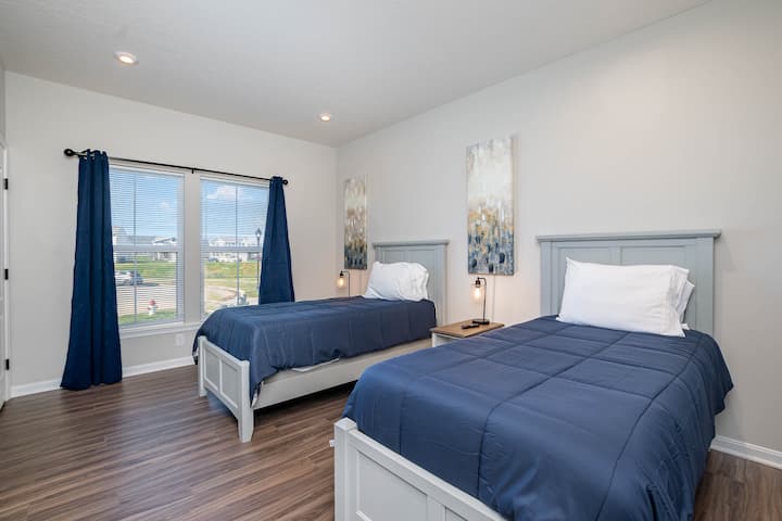 Ova spavaća soba ima dva odvojena kreveta, veliki ormar i TV ravnog ekrana.