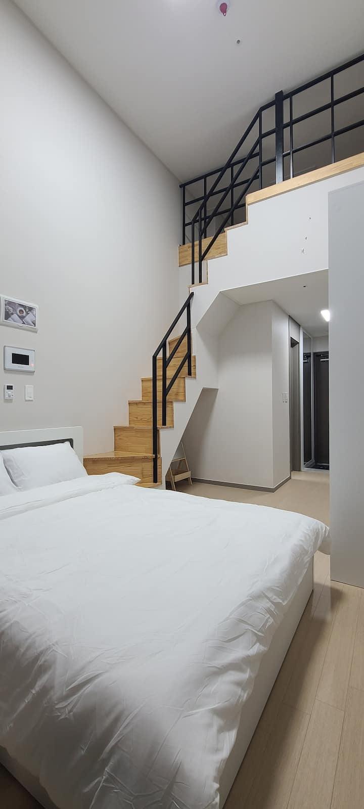 Დედოფლის ზომის საწოლი პირველ სართულზე და კიბე მეორე სართულზე