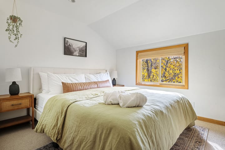 Bedroom 3 - the cozy master retreat equipped with a Cal King Casper hybrid memory foam mattress, crisp cotton linens and a serene view of the trees through the window. 