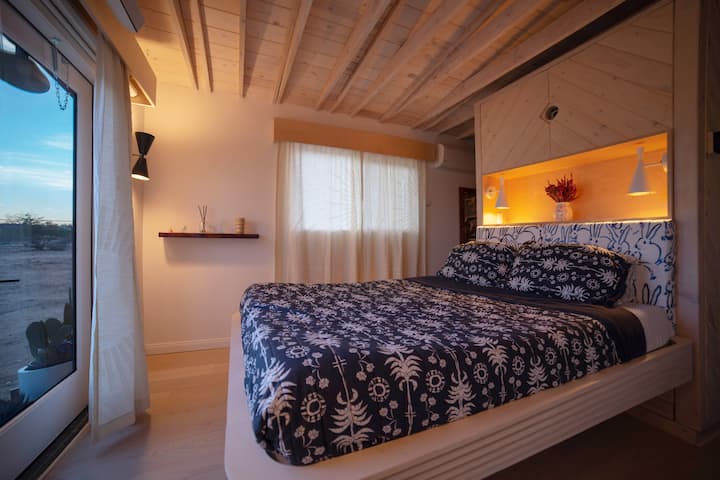 Dormitorio principal con vistas al exterior a través de puertas francesas