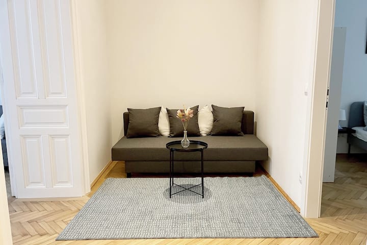 Sala de estar: entre los dos dormitorios hay un salón con un cómodo sofá, una mesa de comedor y un armario. 