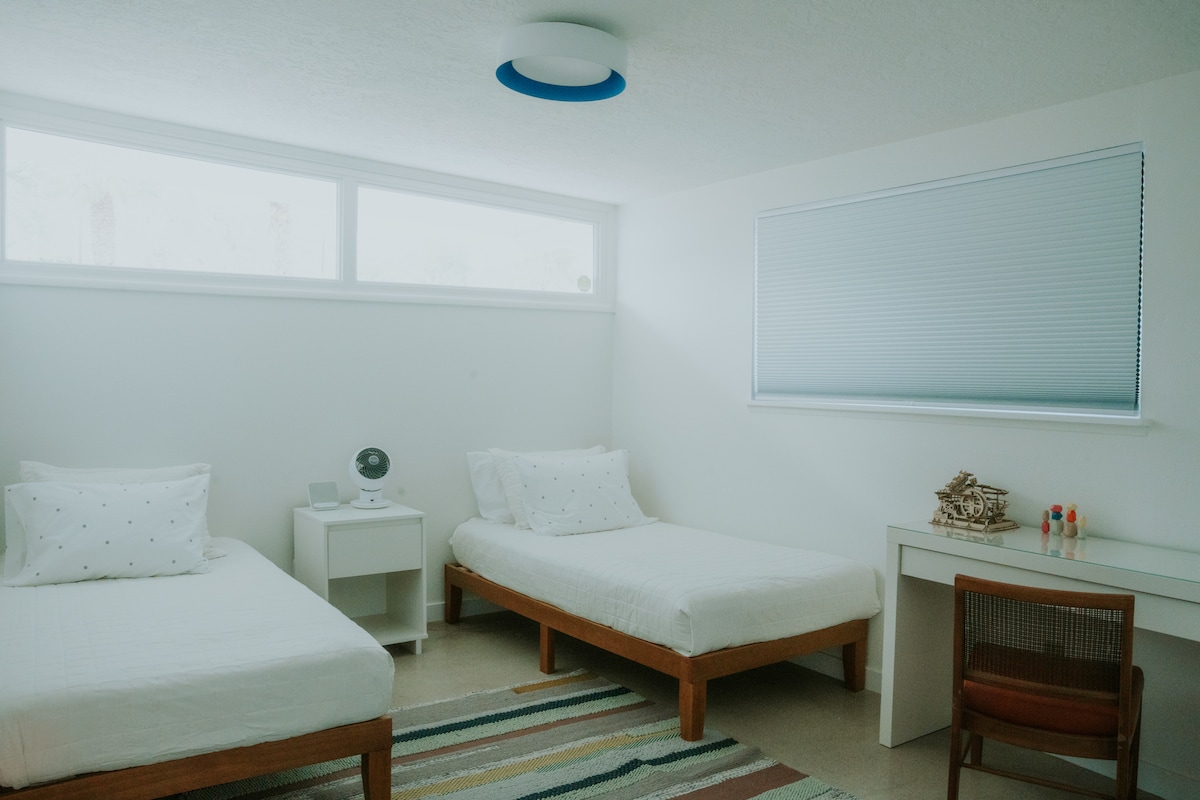 Táto svetlá a moderná druhá spálňa má dve jednoduché a elegantné dvojlôžkové postele, písací stôl a šatník s vešiakmi a komodu. 