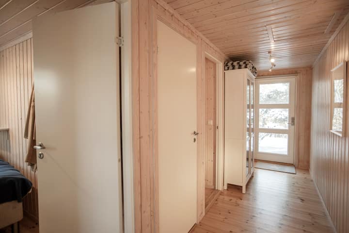 Njia ya chumba cha kulala ina taa zilizo na milango iliyofunikwa na dirisha kila upande. Kushoto: Chumba cha kulala kilicho na vitanda viwili (au vitanda viwili vya mtu mmoja), kisha mlango wa choo, kisha mlango wa kuingia kwenye chumba cha kitanda cha 1.20 na baada ya kabati ni chumba cha kulala cha ghorofa. Picha: Mette Randem