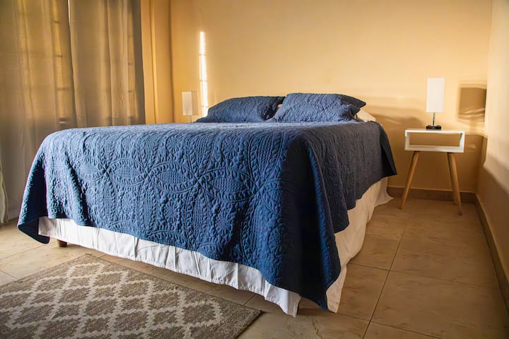 Recámara en la parte exterior de la casa con cama queen size y baño propio