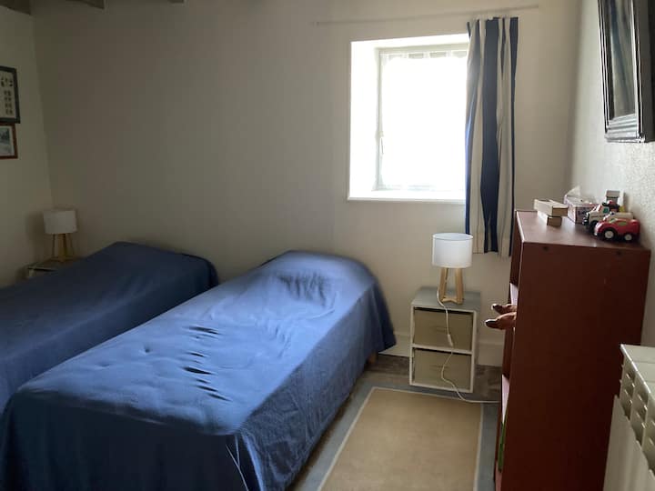 habitación con 2 camas en la planta baja, con libros y juegos para niños pequeños