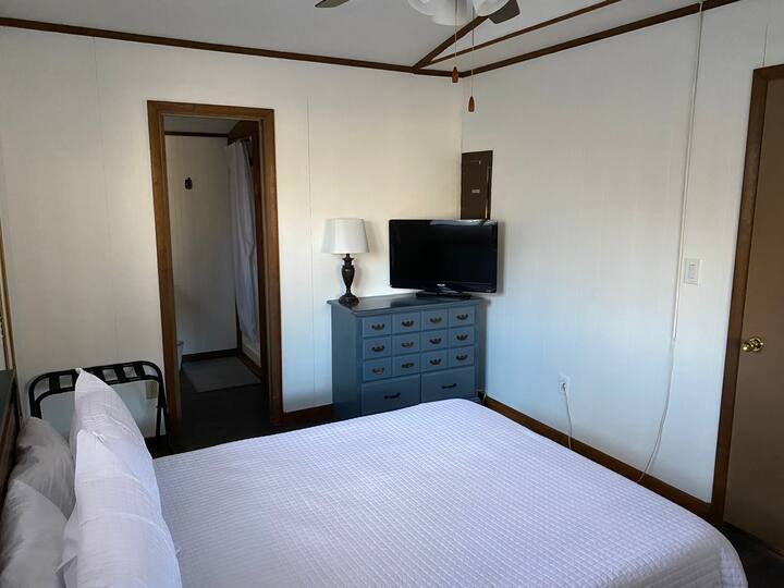 エンスイートバスルーム付きの下層のマスターベッドルーム、Rokuストリーミング付きテレビ、衣類収納と荷物棚