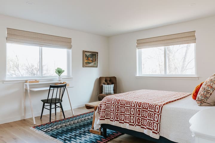 Dormitorio 1 con una cama queen y un espacio de escritorio