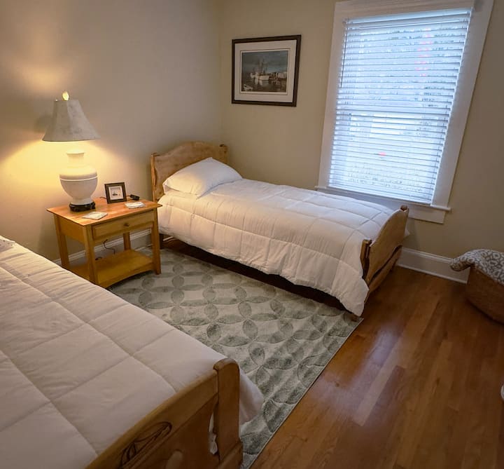 غرفة النوم الثانية مع طاولة للكي ومكواة في الخزانة.  