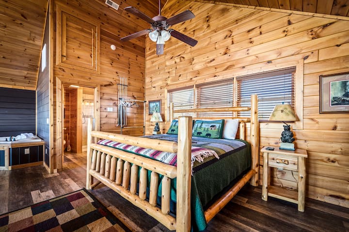 (King) bed upstairs. The sleeping space includes nightstands, a dresser, and a large Smart TV. A full bathroom is right next to the bed and there are also bunk beds for the kids nearby.