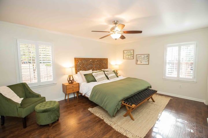 Master bedroom with comfortable king size bed, quality pillows and linens, 55" Roku TV, plantation shutters, remote ceiling fan, full length mirror, and remodeled en suite bathroom.