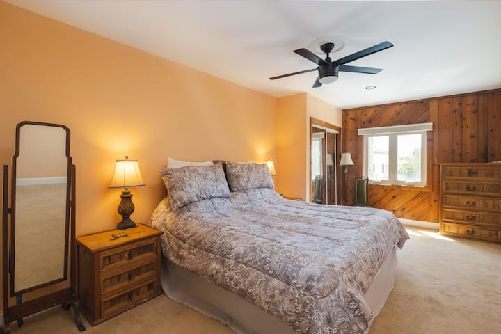 חדר שינה קינג בקומה השלישית עם דלת מקשרת לחדר הרחצה במסדרון. 