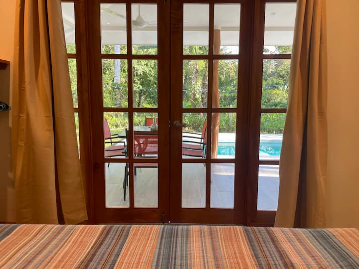 Dormitorio king en la planta baja con puertas hacia el patio junto a la piscina. 