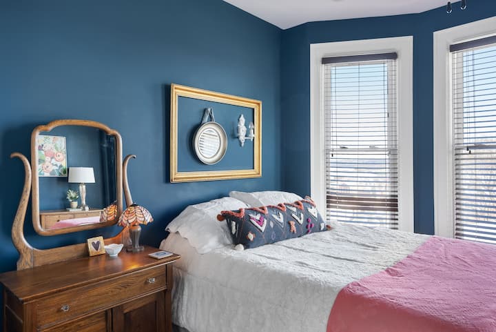 Bedroom #3 (of 4) includes a queen bed and views of downtown Dubuque through a bay window.