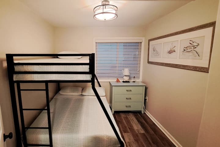 טווין מעל מיטת קומותיים מלאה. יש כריות, שמיכות טלאים ומגני מזרנים. האורחים צריכים להביא סדינים משלהם.