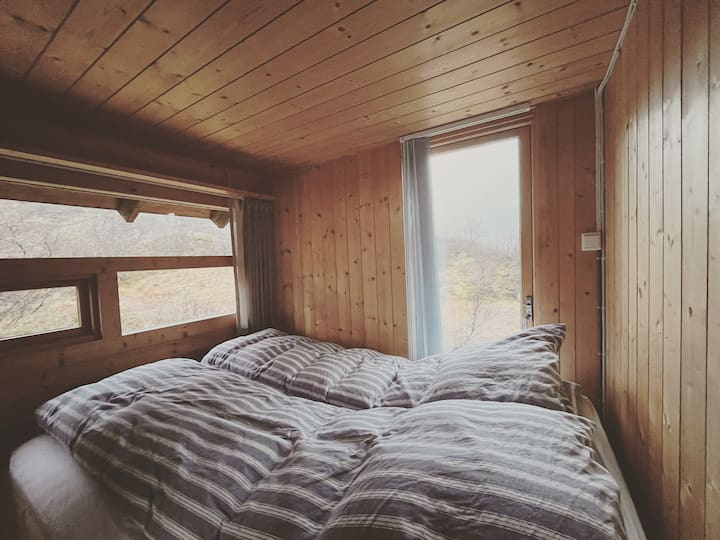 Soverom 1 m/ dobbeltseng og flott utsikt mot naturen. Hytta har ellers hems med soveplass til to.