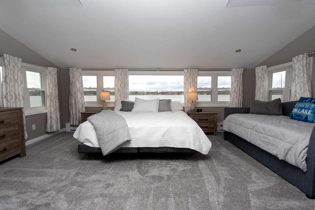 Chumba kikubwa cha kulala chenye kitanda cha kifalme kinachoangalia ziwa