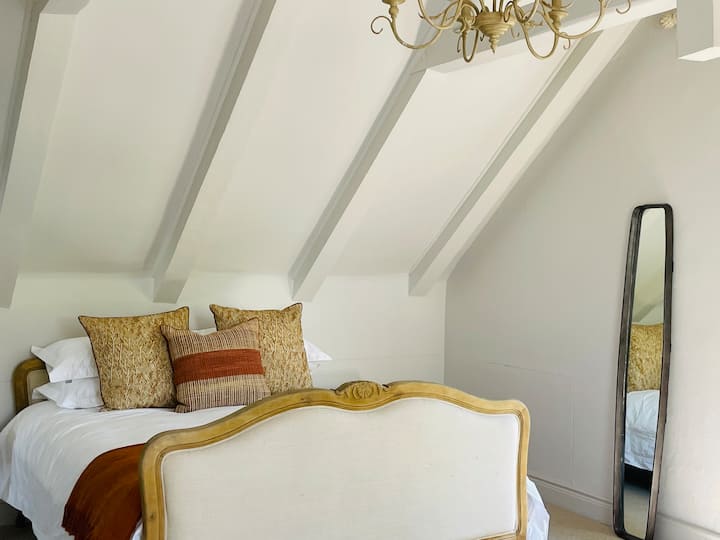 espacioso dormitorio loft con cama tamaño queen.