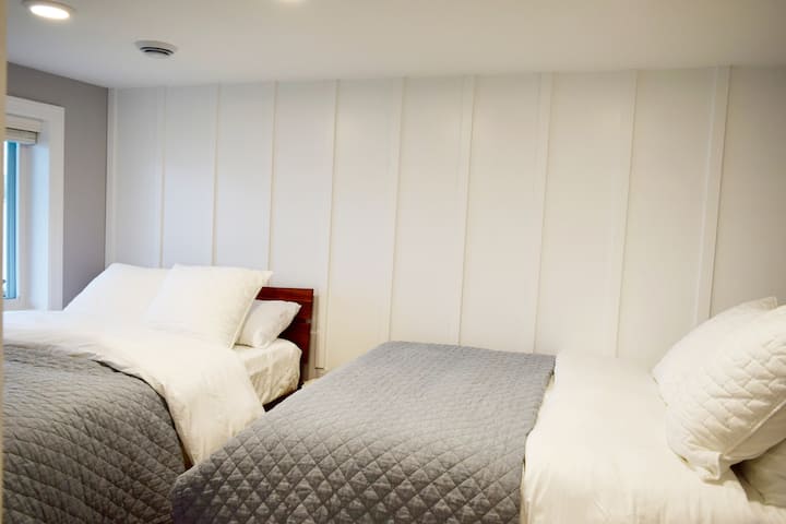 ห้องนอนชั้นล่างนี้มีเตียงควีนไซส์ 2 เตียงนอนได้ 4 คน มีพื้นที่ตู้เสื้อผ้าเพิ่มเติมด้วย วิวทะเลสาบจากห้องนี้ขณะนอนอยู่บนเตียง 