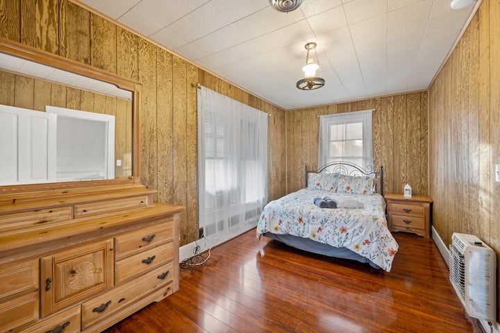 This room features a queen bed, dresser, nightstand and bathroom access.  There are also some historic features in this room too!