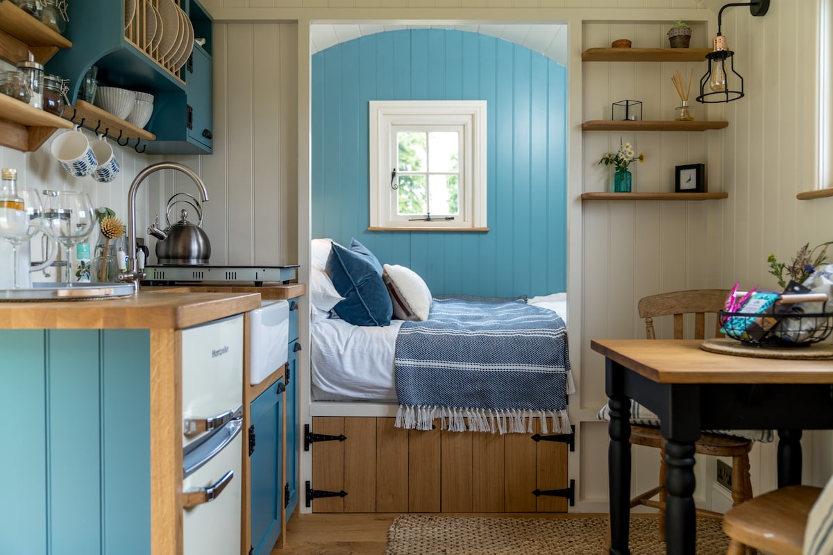 Skylark Shepherds Hut is piepklein, met een groot tweepersoonsbed gekleed in luxe katoenen beddengoed en gezellig dekbed.  De waterkoker is zo dichtbij dat je in bed kunt genieten van thee!  Perfect voor luie ochtenden!