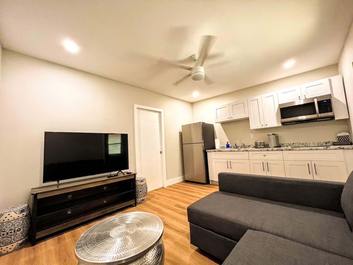 Relájate con estilo en esta sala de estar adornada con comodidades modernas. Un gran televisor de pantalla plana ocupa el centro del escenario con un telón de fondo de una decoración de buen gusto. Los lujosos asientos invitan a la relajación, ofreciendo un espacio perfecto para disfrutar del entretenimiento y el ocio.
