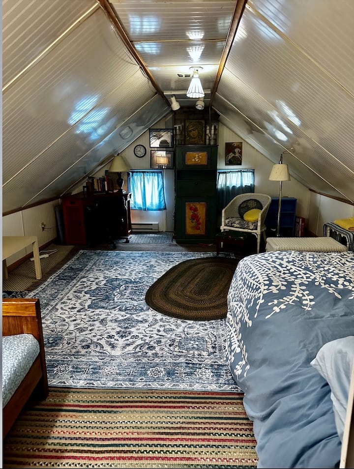 בסטודיו Attic יש מיטה מלאה, ויחידות חימום ומזגן משלו. שימו לב לתקרה המשופעת! לסטודיו אורות משלו; אבל שמרו על עליית הגג הראשית דולקת כשאתם שם למעלה. המתג נמצא על הקיר השמאלי כשאתם עולים במדרגות עליית הגג.