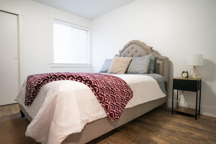 מיטת קווין סייז. בחדר יש ארון מלא, שולחן עבודה וכיסא, דלת לחדר הרחצה