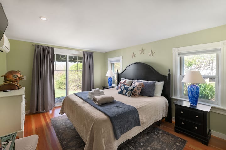 Bedroom #1: Primary bedroom on the first floor with king bed and en-suite bathroom, screen door to side yard