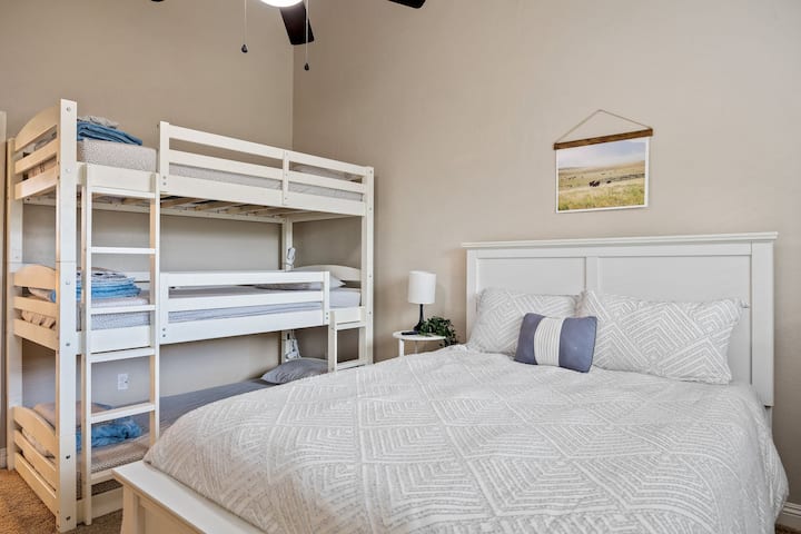 upstairs bedroom with three level bunk bed and queen bed