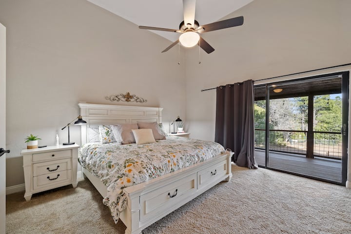 master bedroom with electric fireplace, balcony, and king bed