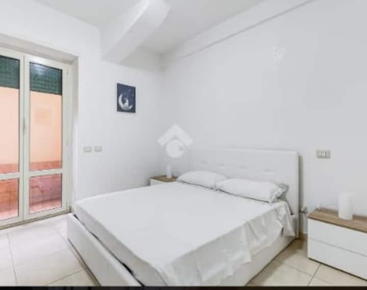bedroom with a double bed and a window door that leads to a small outdoor patio 