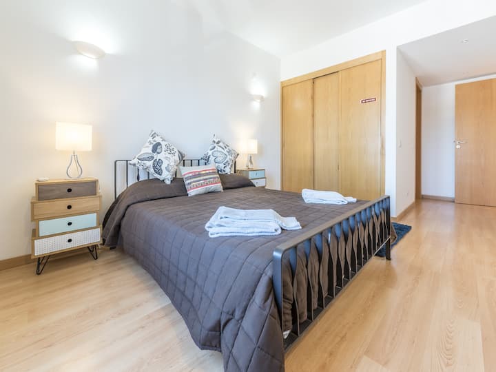 Slaapkamer met tweepersoonsbed in Appartement Beleza		Een van de slaapkamers in Appartement Beleza beschikt over een comfortabel tweepersoonsbed. Deze kamer is ontworpen voor ontspanning met veel daglicht en een gezellige sfeer, en biedt een rustgevend toevluchtsoord voor gasten.			