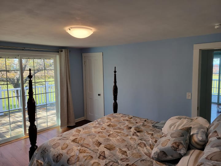 Chumba cha kulala 1: Kitanda cha ukubwa wa malkia kilicho na ufikiaji wa sitaha na mwonekano wa shamba la mizabibu na ziwa. Kabati ya kuning 'iniza nguo.