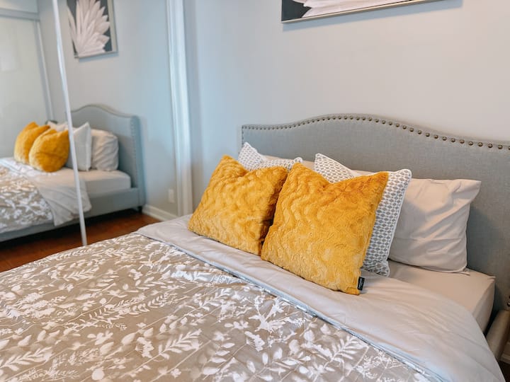 1 cama queen cómoda en el dormitorio con sábanas de algodón y almohadas adicionales