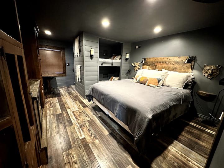 Dhoma e gjumit në katin e poshtëm ka dy krevate dopio tepër të gjatë dhe karikim me valë në tavolinën pranë krevatit.