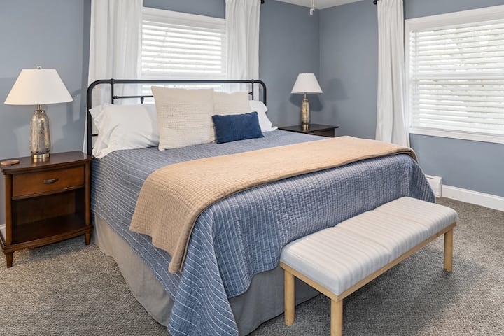 Suite #1 with King size bed and attached full bathroom with double sink. Mattress is firm. Across from the bed is a large dresser and Roku TV.