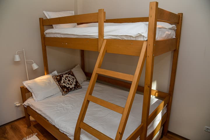 Dviaukštė lova miegamajame pirmame aukšte ir viename antrame aukšte.