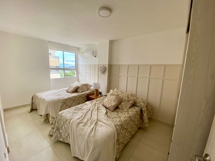 เตียงเรียบง่าย 2 เตียงในห้องที่มีรายละเอียดที่สวยงามและอบอุ่น ตู้เสื้อผ้ากว้างขวางเครื่องปรับอากาศแบบแยกส่วนขนาดเล็ก