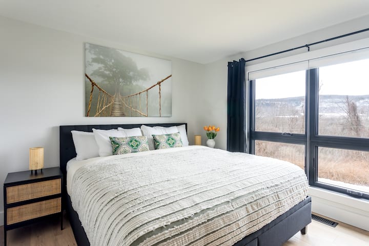 Chambre principale avec lit King Size. Fenêtres surdimensionnées pour une lumière puissante.  Rideaux occultants pour l'éloigner.