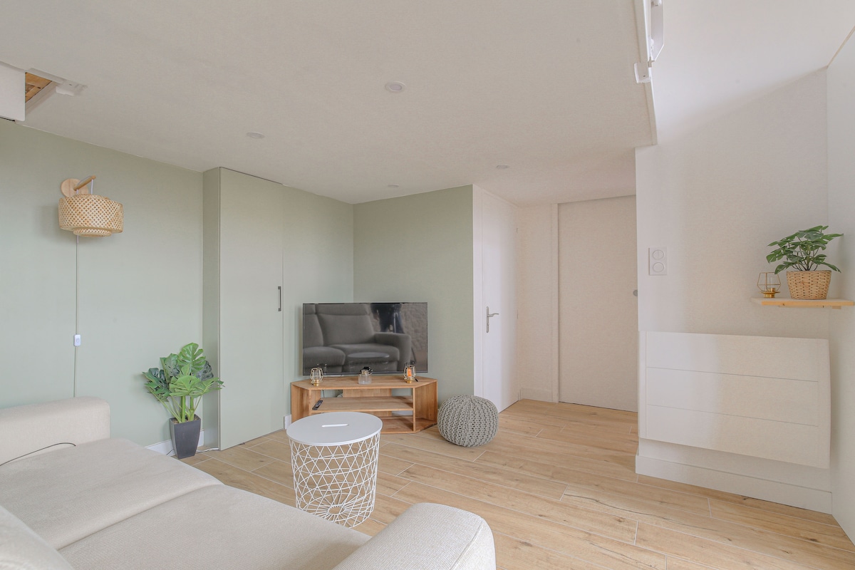 Posedenie s pohodlnou pohovkou, TV skrinkou a výzdobou pod medziposchodím